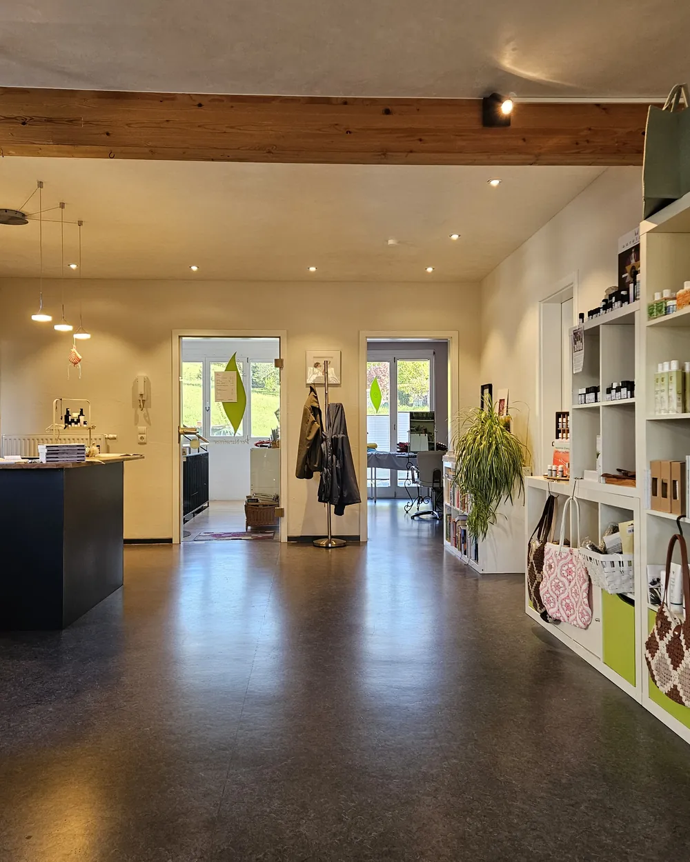 Blick in den hellen Salon Vitanico mit Produktregalen und Holzbalken